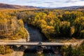 SUV on wooden bridge over small mountain river. Autumn forest Royalty Free Stock Photo