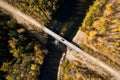 SUV on wooden bridge over small mountain river. Autumn forest Royalty Free Stock Photo