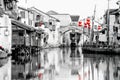 Suzhou, ancient chinese canal, old houses, lanterns, wooden boats and ancient bridge near Shanghai, China. Black, white, red image Royalty Free Stock Photo