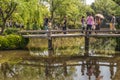 People on bridge over pond at Humble Administrators garden, Suzhou, China