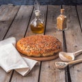 Svesenamilna, home-baked homemade bread, sesame seeds on a rustic plank table, wooden spoons, vegetable oil in the background Royalty Free Stock Photo