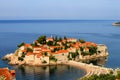 Sveti Stefan, a beautiful resort island in Adriatic Sea in Montenegro. Old houses with red, orange roofs in the bay Royalty Free Stock Photo