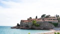 Sveti Stefan historical town island and paradise sand beach. Budva, Montenegro. Hotel in a small rock in the adriatic sea in a Royalty Free Stock Photo