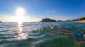 Sveti Stefan - Man bathing in crystal clear water at sand beach next to idyllic island Sveti Stefan, Budva Riviera, Montenegro