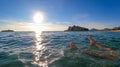 Sveti Stefan - Man bathing in crystal clear water at sand beach next to idyllic island Sveti Stefan, Budva Riviera, Montenegro Royalty Free Stock Photo