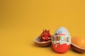 Sveti Vlas, Bulgaria - July 3, 2023: Kinder Surprise Eggs, plastic capsule and toy on yellow background, space for text