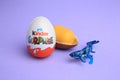 Sveti Vlas, Bulgaria - June 30, 2023: Kinder Surprise Eggs, plastic capsule and toy on violet background