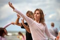 Female dancers dancing to music on beach by sea, dancers at outdoor art performance music festival