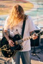 Rock musician playing guitar at outdoor heavy metal grunge festival, strum guitar, rock performance