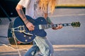 Rock musician playing guitar at outdoor heavy metal grunge festival, strum guitar, rock performance