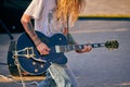 Rock musician playing guitar at outdoor heavy metal grunge festival, strum guitar, rock performance