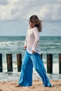 Woman dancer in ethnic blue and white clothes dancing on beach, outdoor dancing performance