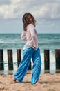 Woman dancer in ethnic blue and white clothes dancing on beach, outdoor dancing performance