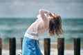 Woman dancer in ethnic blue and white clothes dancing on beach, outdoor dancing performance