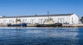 Svitzer Eureka and SL Daintree towboats docked at a large warehouse facility