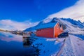 SVOLVAER, LOFOTEN ISLANDS, NORWAY - APRIL 10, 2018: Outdoor view of cars parked at red rorbu or fisherman`s houses close Royalty Free Stock Photo