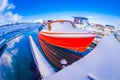 SVOLVAER, LOFOTEN ISLANDS, NORWAY - APRIL 10, 2018: View of fishing boats covered with snow in harbour with buildings in