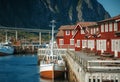 Svolvaer, Lofoten norway, boat in port, mountains and traditional red rorbu fishing houses, beautiful cityscape
