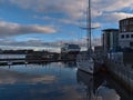 Tranquil harbor of Svolvaer in evening light with docking sailing yacht and Hurtigruten cruise ship.