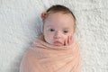 Alert Baby Girl Swaddled in a Light Peach Wrap