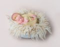 Swaddled kid napping on yellowish furry pillow