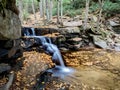 Swallow Falls State Park in the mountains of Maryland in the fall with fallen leaves all over the ground and in the water and a Royalty Free Stock Photo