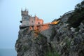 The Swallow`s Nest Tower illuminated by a searchlight at night. View from the shore.