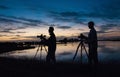 Swamp landscape, silhouette of photographers with photo tripods against the backdrop of the sunset over the swamp. Louisiana, USA