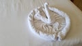 swan folded from white towels on bed in an old hotel room, top view Royalty Free Stock Photo