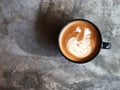 Swan shape latte art coffee in Black cup on beauti cement floor with natural light Royalty Free Stock Photo