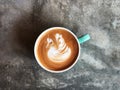 Swan shape latte art coffee in white and green cup on cement floor with natural light Royalty Free Stock Photo