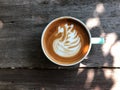 Swan shape latte art coffee in white and green cup on wooden table with natural light Royalty Free Stock Photo