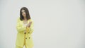 Pretentious brunette woman in yellow formal suit clapping, and looking annoyed over white background