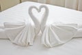 Swans made from towels on the bed.