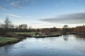 Swans on riverbank during beautiful frosty Winter sunrise landscape