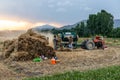 Swat, Pakistan - 24 May 2023: Farmer holding and carrying wheat crop bundle to operate the thresher machine in the fields at swat