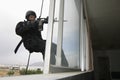 SWAT Team Officer Rappelling And Aiming Gun