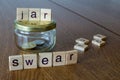 Swear jar on the wooden table background. Letters on wooden blocks Royalty Free Stock Photo
