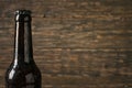 Sweating, cold bottle of beer closeup on dark wooden background Royalty Free Stock Photo