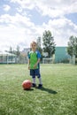 Sweaty focused little soccer player during match on football field, real fan and future champion