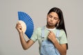 Sweaty exhausted teenage girl using paper fan suffer from heat. Overheating, stuffiness, hot weather Royalty Free Stock Photo