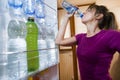 Sweaty woman drinking water seen from inside the fridge