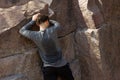 Sweaty young man holding on rock while climbing Royalty Free Stock Photo