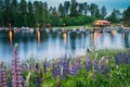 Sweden. Beautiful Red Swedish Wooden Log Cabin House And Pier Near Lake In Summer Evening Night. Lake Or River Landscape Royalty Free Stock Photo