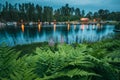 Sweden. Beautiful Red Swedish Wooden Log Cabin House And Pier Near Lake In Summer Evening Night. Lake Or River Landscape Royalty Free Stock Photo