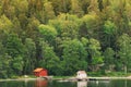 Sweden. Beautiful Red Swedish Wooden Log Cabin House On Rocky Island Coast In Summer. Lake Or River And Forest Landscape Royalty Free Stock Photo