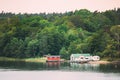 Sweden. Beautiful Red Swedish Wooden Log Cabin House On Rocky Island Coast In Summer. Lake Or River And Forest Landscape Royalty Free Stock Photo