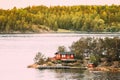 Sweden. Many Beautiful Red Swedish Wooden Log Cabin House On Rocky Island Coast In Summer. Lake Or River Landscape Royalty Free Stock Photo