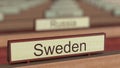 Sweden name sign among different countries plaques at international organization. 3D rendering