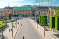 Sweden, Stockholm, May 29, 2018: Riksplan green grass lawn, bushes and street with national flags